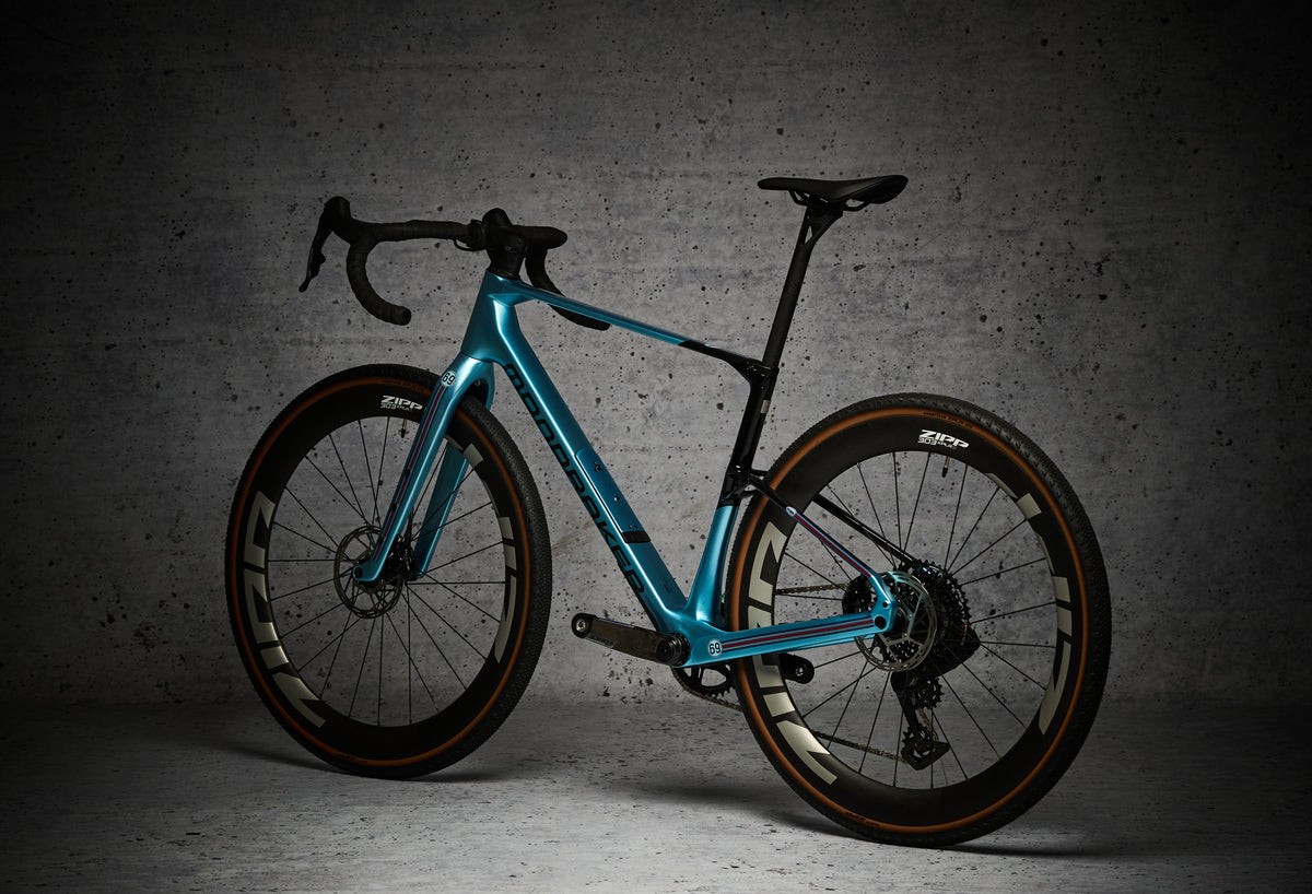 Bici gravel azzurra con protezione NEO Racing Gravel, vista a tre quarti