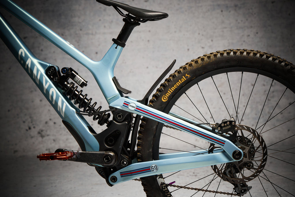 Protezione NEO Racing sul fodero orizzontale e vicino all’ammortizzatore posteriore di una MTB azzurra